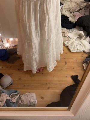 Vit långkjol från Natura - Säljer en vit långkjol från Natura i storlek S. Kjolen har en luftig och flowy passform med resår i midjan och är gjord i ett tunt, mjukt bomullstyg. Perfekt för varma dagar och enkel att styla med olika toppar.