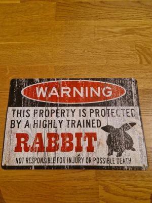 Rolig varningsskylt - Rolig skylt för dig som har en kanin och vill smycka ditt rum elr där kaninen bor ( under leveransen när den kom till mig så hade den blivit sne så är lite sne och bucklig)