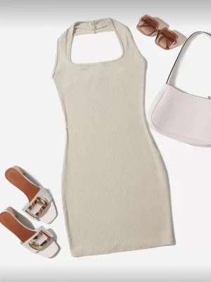 Beige ribbad halterneck klänning - Säljer denna trendiga klänning med halterneck och fyrkantig urringning som aldrig kommit till användning. Klänningen är kort och har en tight passform som framhäver figuren. Perfekt för dig som gillar minimalistisk och stilren design. Tillverkad i mjuk bomullsmix för skön känsla.❣️