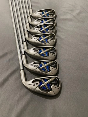 Callaway X-22 Järnset 4-P - Säljer ett set med Callaway X22 järnklubbor, totalt sex stycken. Klubborna är i silverfärgat stål med blå och svarta detaljer på klubbhuvudet. Snygg och modern design, perfekt för dig som vill ta ditt golfspel till nästa nivå. Setet innehåller klubbor från 5 till pitching wedge.