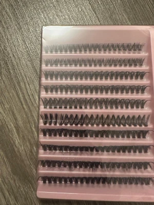 Kit med individuella lösögonfransar - Ett komplett kit med individuella svarta lösögonfransar, . Fransarna är i olika längder och har en naturlig böj. Allt levereras i en rosa plastförpackning. Perfekt för att skapa en personlig franslook. Nyskick, PRISET GÅR ATT DISKUTERA!!