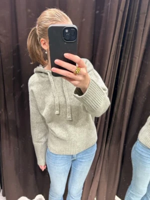 Grå stickad hoodie från ZARA - Mysig grå stickad hoodie från ZARA med huva och dragsko. Säljer den i storlek S.❤️ Säljer då den inte kommer till användning längre.