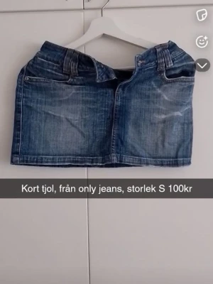 Blå jeanskjol från Only - Säljer en blå jeanskjol från Only med klassisk femficksdesign och bälteshällor. Kjolen är kort och har en rak passform, perfekt till sommaren. Tillverkad i slitstarkt denimtyg som ger en avslappnad och trendig look.