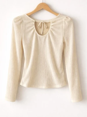 Vit blus med detaljer  - Trendig vit topp med lång ärm och snygg struktur i tyget. Toppen har en öppen rygg med knytband upptill som ger en unik detalj. Även liten puff vid axlarna 