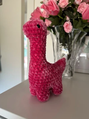 Virkad rosa dinosaurie  - Virkad rosa dinosaurie som är ungefär 20 cm hög. Dinosaurien har säkerhetsögon som inte är lämpliga för barn under 3 år💗