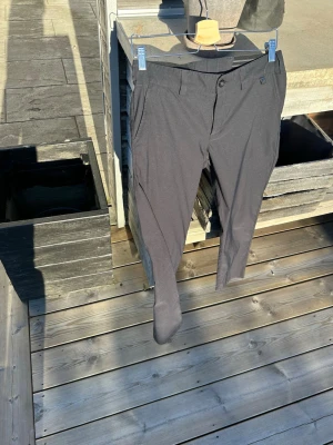 Svarta golfbyxor från Peak Performance  - Snygga svarta golfbyxor från peak performance . Byxorna har framfickor, bälteshällor och knappgylf. Perfekta för dig som vill ha ett stilrent och enkelt plagg att matcha med.