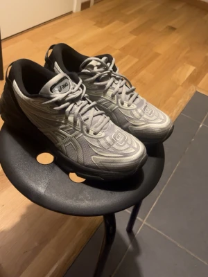 ASICS x C.P. Company Gel-Quantum 360 - Snygga sneakers från ASICS och C.P. Company i modellen Gel-Quantum 360. Skorna är gråa med svarta detaljer och har en futuristisk design med reflekterande mönster. Ovandelen är i mesh och syntet, och sulan är rejält dämpad för extra komfort.