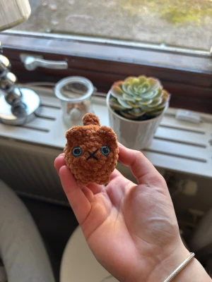 Virkad liten katt - Super söt virkad liten katt som är orange/brun med blå ögon. Ca 8 cm lång (svans inkluderad). Katten har säkerhetsögon som inte är lämpliga för barn under 3 år💗