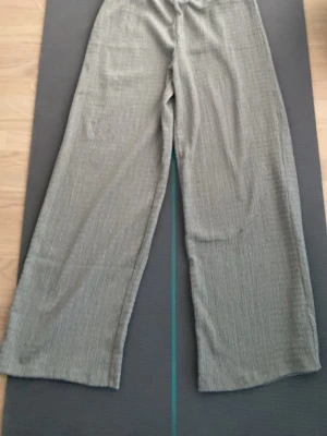 Gröna vida leggings - Säljer ett par grå leggings med vida ben. De har hög midja och är tillverkade i ett mjukt, stretchigt material som ger en avslappnad och trendig look. Perfekta för dig som gillar bekväma men snygga byxor.