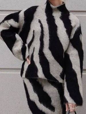 Stickad tröja zebramönster  - Säljer den supersnygga trendiga tröjan med zebramönster från H&M, i svart och beige - mohair. Tröjan har högre hals, långa ärmar och är gjord i ett fluffigt material som ger en cool och trendig look. Super fint skick! Storleken är M men passar även S 🥰Tröjan är slutsåld och eftertraktad - därav pris! 