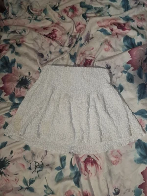 Vit kortkjol i frotté - Supersöt vit kortkjol i mjuk frotté med lätt utställd form och resår i midjan. Perfekt för en avslappnad och trendig look. Passar till både sneakers och sandaler.