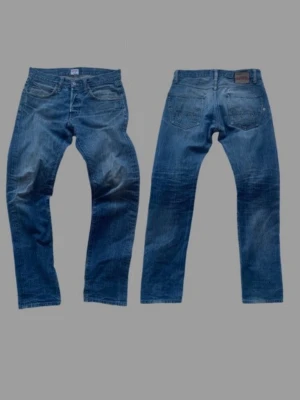 Japanska jeans från Edwin  - Säljer ett par riktigt snygga japanska jeans från Edwin. Jeansen har snygga unika slitningar och är tillverkade i blå denim. Något mer avslappnad passform (tänk mellan nudie jeans Grim Tim och gritty Jackson typ). Storlek 32/34. Höra gärna av er vid frågor/fler bilder! 
