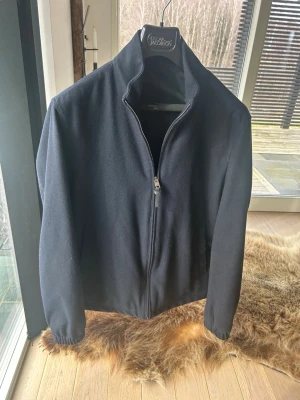 Mörkblå jacka från Mango Essentials  - Mörkblå jacka från Mango Essentials  med hög krage och dragkedja framtill. Jackan har en minimalistisk design och är tillverkad i ett mjukt material som känns exklusivt. Perfekt för dig som gillar klassisk och enkel stil. Storlek M i jättefint skick!