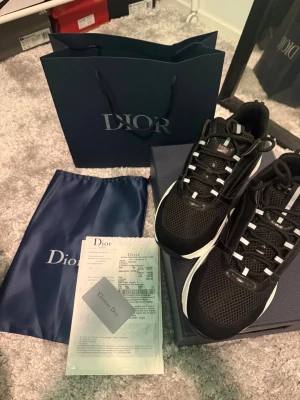 Skor  - Säljer ett stilrent svart armband med deras ikoniska mönster. Kommer i originalförpackning. Helt ny aldrig använd. OBS PRIS KAN DISKUTERAS OCH SKRIV FÖR FLERA BILDER.