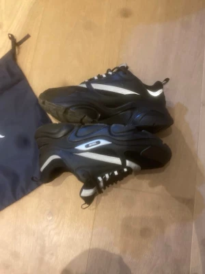 Svarta och vita sneakers med meshdetalj - Hej säljer ni dessa b22 för ett lågt pris för som ni ser på bild 2 är ena binden av på höger sida vilket gör man inte kan stoppa in snöret men man ser inte det mycket als för det är den högst upp. Dem passar 43 och 42 tycker jag och det är bara att höra av om ni har frågor✅👍 tar byte också