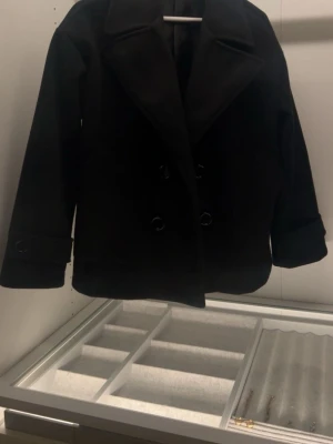 Svart Designby si kappa - Stilren svart kappa ifrån desginby si i storlek xs/s