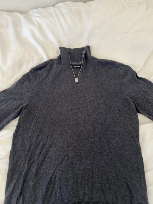 Mörkgrå halvzip tröja Jack & Jones - Mörkgrå långärmad tröja från Jack & Jones med halv dragkedja framtill och hög krage. Tröjan är i mjukt material och har en enkel, stilren design som passar perfekt till jeans eller chinos.