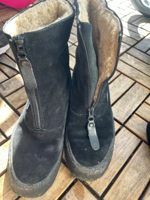 Svarta mockastövlar från Sanders - Säljer ett par svarta stövlar från Sanders i mocka med dragkedja framtill och mjukt, beige foder på insidan. Stövlarna har en robust sula och enkel, stilren design som passar perfekt till höst och vinter. Klassisk look med diskret logga på sidan. Nypris 4300kr