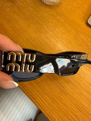 Svarta solglasögon  - Snygga svarta solglasögon med rektangulär form och breda bågar. Likt miu miu men är inte det