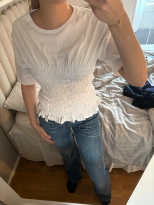 Vit smockad topp med volangkant - T- shirt från Nelly aldrig använt