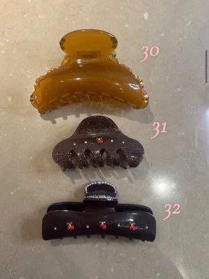 Bruna och beige hårklämmor  - Säljer 3 olika hårklämmor, 1 för 95 2 för 175 och 3 250. De är bruna och beige med detaljer så som körsbär och stenar/pärlor. 