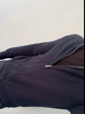 Marinblå ziptröja från J.Lindeberg - Snygg marinblå ziptröja från J.Lindeberg med hög krage. 