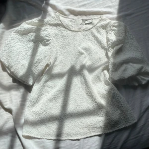 Vit strukturerad blus från JDY - Vit blus från JDY med puffiga, korta ärmar och en snygg struktur i tyget. 