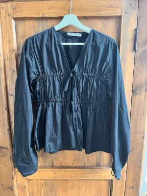 Svart blus med knyt från NA-KD - Snygg svart blus från NA-KD med långa ärmar och smockdetaljer i midjan. Jätte fin, storlek s🫶🏼💕