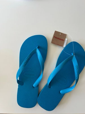 Blå flip-flops från Havaianas - Snygga blå flip-flops från Havaianas perfekt till sommaren. Storlek 41-42. Dem är hel oanvända!
