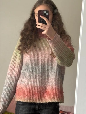 Stickad tröja i pastellfärger - Pastellfärgad stickad tröja med halvhög hals. Tröjan har  rak passform, ribbstickade muddar och är gjord i ett fluffigt garn som ger en mysig känsla. Har ett litet hål vid axeln som knappt syns (med på bild 2), och är lite nopprig, men inte särskilt synligt. Säljs då den inte längre kommer till användning. Skriv bara om du vill se mer bilder eller har någon fråga☺️💛