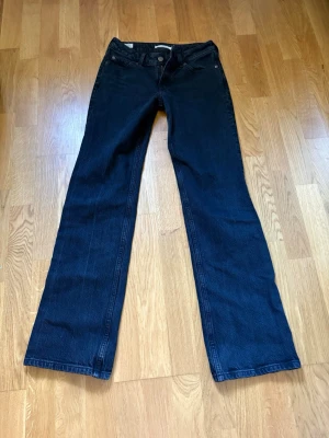 Svarta bootcut jeans Levi’s - Snygga mörkblå bootcut jeans från Lee med låg midja och klassisk femficksmodell. Jeansen är tillverkade i ett slitstarkt denimtyg och har bälteshällor samt dragkedjegylf. Perfekta för en avslappnad och trendig look.
