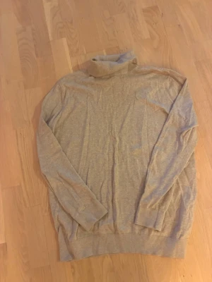 Beige polotröja från H&M - Snygg beige stickad polotröja från H&M med lång ärm och ribbade muddar. Perfekt för lager-på-lager och enkel att matcha med olika outfits. Mjuk och skön känsla tack vare det tunna stickade materialet.