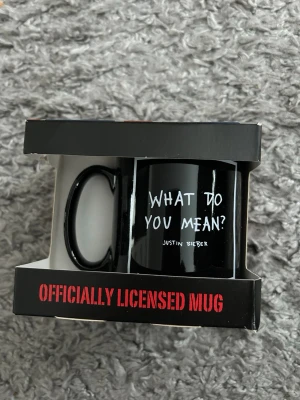 Justin Bieber svart mugg - Säljer en svart keramikmugg med texten 'What Do You Mean?' och Justin Bieber tryckt på framsidan. Muggen är officiellt licensierad och levereras i originalförpackning. Perfekt för fans av Justin Bieber Helt ny..