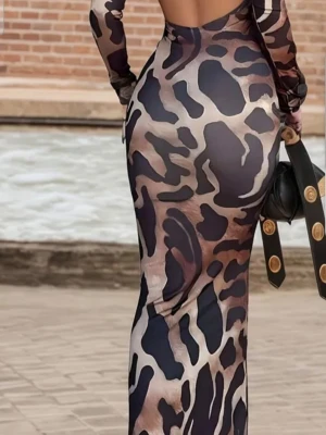 Leopardmönstrad lång klänning - Säljer en lång, tight klänning med leopardmönster i mörka och beige toner. Klänningen har långärmade ärmar och en öppen rygg som ger en cool och trendig look. Perfekt för dig som vill sticka ut och gillar djurmönster.