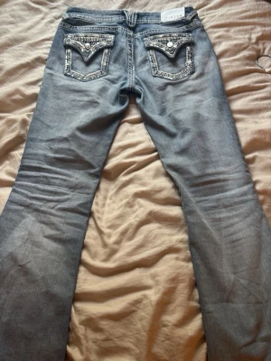 Snygga jeans med detaljer på backfickorna från Vigoss💕 - Jättesnygga jeans med deltaljer på backfickorna och stjärnor på knäna. Liknar miss me jeans💕 har använt fåtal gånger. Frakt ingår, 35kr