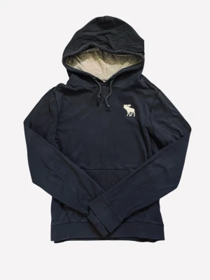 Mörkblå hoodie från Abercrombie & Fitch - Svart hoodie från Abercrombie & Fitch med klassisk huva och dragsko. På bröstet finns en broderad vit älg-logga. Skick 9/10,  inga hål. Hör av dig vid minsta fundering