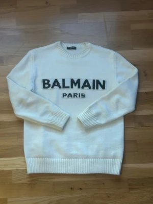 Balmain Stickad Tröja  - Säljer en vit stickad tröja från Balmain Paris, storleken är M men passar som L mer som loose fit 😊.                                                                                    Pris är diskuterbart 