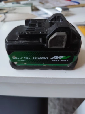 Hikoki Multi Volt batteri 36V/18V - Säljer ett Hikoki Multi Volt batteri med kapacitet för både 36V och 18V. Batteriet är svart med gröna detaljer och har Li-ion teknik. Passar till Hikoki elverktyg och har en robust form med metallklämma på sidan.