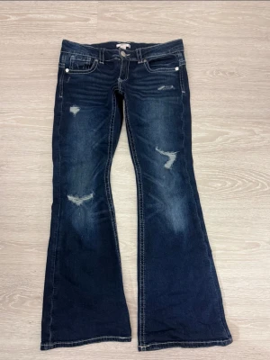 Ginatricot Jeans - Mörkblå ultra low bootcut jeans från Ginatricot med slitna detaljer framtill. Storlek 170 och endast testade🩷