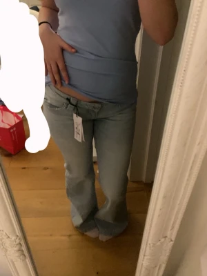 Ljusblå bootcut jeans med strass - Säljer ett par ljusblå bootcut jeans med strassdetaljer på bakfickorna. Jeansen har klassisk femficksmodell, hällor för skärp och är tillverkade i denim. Perfekta för dig som gillar en avslappnad men ändå trendig look. Använd 0 gånger därför säljer jag för 320kr (då tjänar jag prick 300)