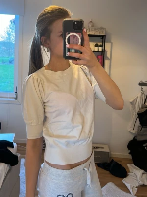 Kortärmad tröja med puffiga armar - Säljer en vit tröja med korta ärmar, ärmarna är lite puffiga men tajta längst ut och den e också tajt i midjan💞