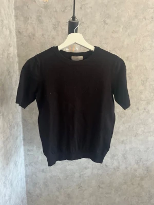Svart stickad kortärmad topp🙌🏻 - Söt svart stickad topp med rund hals och korta ärmar. Toppen är från H&M i storlek xs. Den är ganska nopprig på bilden, men jag har en noppmaskin som jag använder innan jag skickar iväg💞