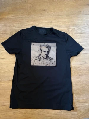 Limitato T-shirt  - Stilren svart T-shirt från Limitato med ett unikt konstnärligt tryck framtill. Perfekt för dig som vill sticka ut med en mer exklusiv och minimalistisk look.  Storlek: M Passform: Normal Färg: Svart Material: 100% merceriserad bomull (mjuk & hög kvalitet) Tillverkad i: Portugal  Skick: Bra skick – inga hål eller större skador (se bilder)  Säljes då den inte används längre. Snabb frakt 🚚