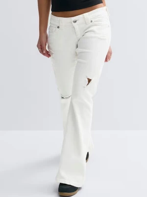 Vita bootcut jeans med slitningar - Snygga vita bootcut jeans med slitningar på låret och vid fickan. Jeansen har klassisk femficksdesign, hög midja och är tillverkade i ett mjukt denimtyg. Perfekta för en trendig och avslappnad look.