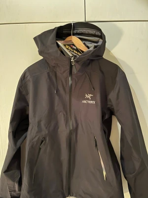 Arc’teryx jacka svart - Säljer min Arc’teryx jacka eftersom som det blev fel storlek jag skulle ha den på påsklovet då jag skulle åka skidor men de blev inte så vill sälja den nu. Har videos på att den är vatten proff och allt det. Finns kvitto ochså men bara på bild då jag inte hittar den. Riktigt fin jacka. ochså bästa rengjackan som finns!😁😁 Helt ny aldrig använt!!