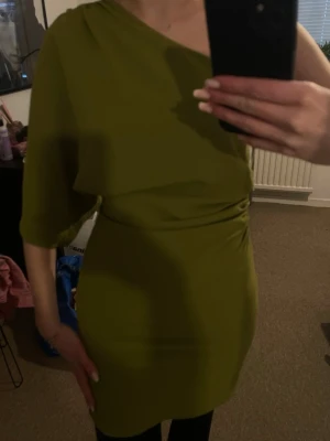 One off shoulder klänning - En super fin one off shoulder klänning från hm i en super fin grön färg, ändast använts 1 gång och därför säljer jag men den är super fin och elegant