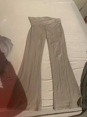 Beiga utsvängda leggings - Aldrig använda. Finns även matchande tröja:Säljer ett par beiga leggings med utsvängda ben och hög midja. De har en mjuk och stretchig känsla, perfekta för en avslappnad och trendig look. Materialet känns tunt och följsamt, vilket gör dem riktigt bekväma att bära.