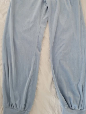 Ljusblåa mjuka loungewear-byxor - Supersköna ljusblåa loungewear-byxor i mjukt fleeceliknande material. Byxorna har resår i midjan och vid bensluten för extra komfort. Perfekta för att chilla hemma eller mysa runt i. Inga synliga loggor eller märken.