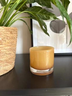 Ljuslykta - Säljer en rund, gul ljuslykta med tjock botten för 50kr