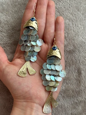 Unika fiskörhängen i guld och pärlemor  - Säljer ett par statementörhängen formade som fiskar. Nyskick! Skickar samma dag eller dagen efter 